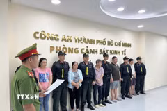 Công an đọc lệnh bắt các đối tượng. (Ảnh TTXVN phát)