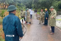 Lãnh đạo xã miền núi Linh Sơn và lực lượng chức năng khắc phục sự cố sạt lở trên tuyến đường trong xã. (Ảnh: Nguyễn Nam/TTXVN)