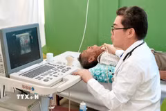 Bác sỹ Tôn Thanh Trà, Giám đốc Bệnh viện Chợ Rẫy - Phnom Penh trực tiếp thăm khám, siêu âm một trường hợp bệnh nhân bệnh nặng, tiếp nhận phẫu thuật miễn phí tại bệnh viện. (Ảnh: Quang Anh/TTXVN)