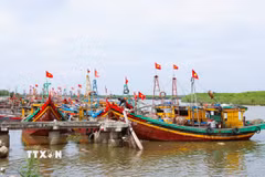 Luồng tuyến neo đậu tàu thuyền trên sông Lạch Vạn (xã Diễn Châu, Nghệ An) nối với cửa biển được điểm tô bởi sắc đỏ cờ Tổ quốc trên hàng trăm tàu, thuyền đánh cá của ngư dân làng biển trong những ngày cận Quốc khánh 2/9. (Ảnh: Xuân Tiến/TTXVN)