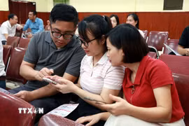 Người dân cài đặt, sử dụng các tính năng của Ứng dụng Công dân số NinhBinh-S. (Ảnh: Nguyễn Lành/TTXVN)
