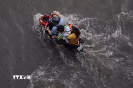 Các phương tiện lưu thông trên đường Trần Xuân Soạn, phường Tân Thuận, bị ngập do triều cường chiều 11/10. (Ảnh: Hồng Đạt/TTXVN)