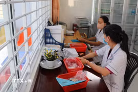 Nhân viên y tế Trạm Y tế tại Đồng Tháp xử lý thông tin bệnh nhân đến khám bệnh trên hệ thống bảo hiểm y tế liên thông. (Ảnh: Hữu Chí/TTXVN)