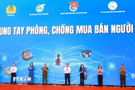 Các đại biểu thực hiện nghi thức thể hiện cam kết phòng, chống mua bán người. (Ảnh: Xuân Triệu/TTXVN