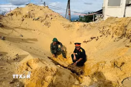 Với sự hỗ trợ của Bộ Chỉ huy Quân sự tỉnh Quảng Trị, lực lượng chức năng tiến hành khảo sát, xử lý di dời an toàn quả bom theo đúng quy định. (Ảnh: TTXVN phát)