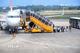 Hành khách xếp hàng lên máy bay tại Cảng hàng không Đồng Hới (Quảng Trị). (Ảnh: Tá Chuyên/TTXVN)