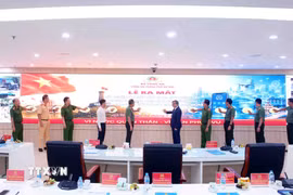 Các đại biểu thực hiện thi thức Lễ ra mắt, giới thiệu dây chuyền sản xuất thiết bị báo cháy không dây; thí điểm ứng dụng Cảnh sát Hà Nội thông minh (Hanoi Smart Police) và triển khai giai đoạn 2 giải pháp UAV giám sát an ninh trật tự. (Ảnh: Phạm Kiên/TTXVN)