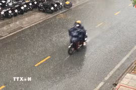 Người dân di chuyển trong cơn mưa lớn. (Ảnh minh họa: Hồng Đạt /TTXVN)