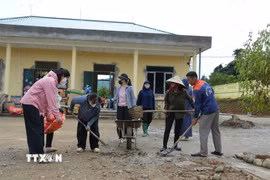 Giáo viên, phụ huynh và công nhân nhà thầu thi công chung tay, khẩn trương dọn dẹp khuôn viên điểm trường Bản Chít của Trường Mầm non Mường Than (Lai Châu). (Ảnh: Việt Dũng/TTXVN)