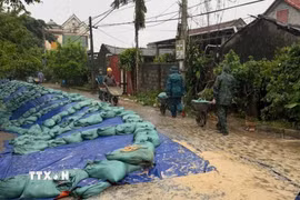 Một đoạn đường sụt lún đã được đắp bao cát nhằm hạn chế sạt lở tiếp tục diễn ra. (Ảnh: TTXVN phát)