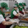 Nhân viên bếp ăn bán trú tại một trường Tiểu học trên địa bàn phường Nha Trang đảm bảo các khâu an toàn trong việc chia, phát thức ăn vào khay trước giờ dùng bữa của học sinh. (Ảnh: Phan Sáu/TTXVN)