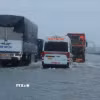Các phương tiện di chuyển chậm qua một đoạn đường bị ngập nước (Ảnh: Hoàng Hiếu/TTXVN)