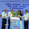 Đại biểu thực hiện hoạt động tưới nước cho cây càphê tại chương trình. (Ảnh: Công Luật/TTXVN)