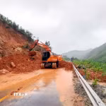 Lực lượng chức năng thu dọn đất đá sạt lở. (Ảnh: Phạm Lợi/TTXVN)