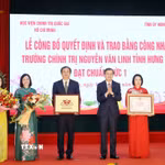 Ủy viên Bộ Chính trị, Giám đốc Học viện Chính trị quốc gia Hồ Chí Minh Đoàn Minh Huấn trao Bằng công nhận Trường Chính trị Nguyễn Văn Linh đạt chuẩn mức 1. (Ảnh: Thế Duyệt/TTXVN)