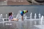 Trẻ em giải nhiệt tránh nóng tại một đài phun nước. (Ảnh: THX/TTXVN)