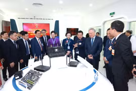 Phó Thủ tướng Thường trực Nguyễn Hòa Bình và các đại biểu tham quan khu trưng bày sản phẩm dịch vụ của VNPT. (Ảnh: P.V/Vietnam+)