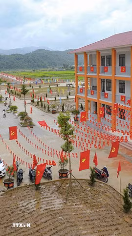 Cờ Đảng, cờ Tổ quốc được trang trí dọc các dãy nhà, tạo sắc màu nổi bật trong khuôn viên Trường Phổ thông nội trú Tiểu học và THCS Sam Mứn. (Ảnh: Xuân Tư/TTXVN)