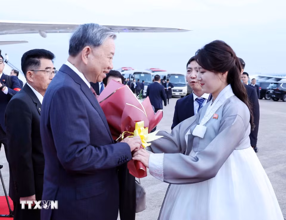 Thiếu nữ Triều Tiên tặng hoa Tổng Bí thư Tô Lâm tại Sân bay quốc tế Bình Nhưỡng. (Ảnh: Thống Nhất/TTXVN)