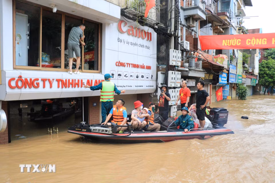 Hàng trăm người được huy động hỗ trợ người dân di chuyển đến nơi an toàn. (Ảnh: Tuấn Anh/TTXVN)