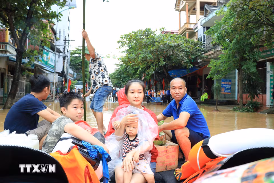 Người dân được lực lượng chức năng tỉnh Lào Cai hỗ trợ di chuyển đến nơi an toàn. (Ảnh: Tuấn Anh/TTXVN)