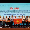 Thứ trưởng Bộ Nông nghiệp và Môi trường Võ Văn Hưng trao quà và cờ tổ quốc cho ngư dân. (Ảnh: Đình Quân/TTXVN)