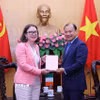 Phó Giáo sư, Tiến sỹ Lê Hải Bình, Phó Giám đốc Thường trực Học viện Chính trị quốc gia Hồ Chí Minh tặng quà lưu niệm cho Đại sứ Ireland tại Việt Nam, bà Deirdre Ní Fhallúin. (Ảnh: Văn Điệp/TTXVN)