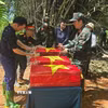 Lãnh đạo tỉnh Lào Cai, phường Cam Đường và lực lượng chức năng thực hiện các nghi thức một cách cẩn trọng, thể hiện lòng thành kính, sự tri ân sâu sắc đối với các Anh hùng liệt sỹ đã hy sinh vì Tổ quốc. (Ảnh: Hương Thu/TTXVN)