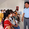 Phó Chủ tịch Ủy ban Nhân dân tỉnh Long An Phạm Tấn Hoà thăm hỏi các gia đình đưa trẻ em đến khám sàng lọc bệnh tim bẩm sinh. (Ảnh: Đức Hạnh/TTXVN)