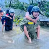 Lực lượng công an Thanh Hóa giải cứu người dân ra khỏi khu vực ngập lụt đến nơi an toàn. (Ảnh: TTXVN phát)
