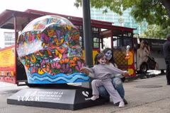 Hai mẹ con chụp ảnh cùng mô hình đầu lâu tại trung tâm thủ đô Mexico City. (Ảnh: Phi Hùng/TTXVN)