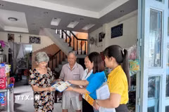 Cán bộ, nhân viên Bảo hiểm xã hội thành phố Cần Thơ tuyên truyền, vận động người dân tham gia bảo hiểm xã hội. (Ảnh: TTXVN phát)