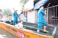 Lực lượng cứu hộ của xã Tiến Thắng đưa học sinh vượt mưa lũ đến trường. (Nguồn: Báo Hà Nội mới)