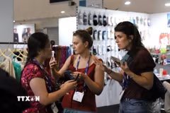 Hai người mua tìm hiểu thông tin sản phẩm tại một gian hàng dệt may Việt Nam tại Source Fashion 2026. (Ảnh: Hữu Tiến/TTXVN)