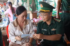 Cán bộ Đồn Biên phòng Cửa khẩu Mỹ Quý Tây (tỉnh Tây Ninh) và người dân. (Ảnh: Bùi Giang/TTXVN)