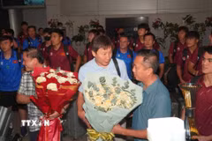 Ban lãnh đạo đội tuyển nhận hoa chúc mừng của các cổ động viên. (Ảnh: Trung Tuyến/TTXVN)