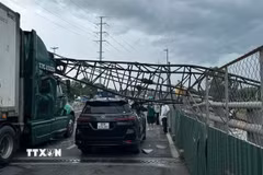 Cần cẩu thi công đè trúng hai xe ôtô trên cầu vượt Mỹ Thủy, thành phố Thủ Đức. (Ảnh: TTXVN phát)