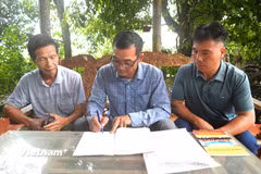 Bí thư Chi bộ Mã Phúc Hương trao đổi những công việc của thôn Làng Hản với các cán bộ của thôn. (Ảnh: Minh Tâm/Vietnam+)