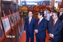Thủ tướng Phạm Minh Chính tham quan trưng bày ảnh về quá trình hình thành và phát triển của Đài Tiếng nói Việt Nam. (Ảnh: Dương Giang/TTXVN)