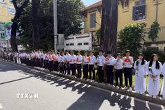 Đông đảo các tầng lớp nhân dân đứng dọc hai bên đường tiễn đưa, tưởng nhớ các Anh hùng liệt sỹ được quy tập tại Công viên Lê Thị Riêng về nơi an táng. (Ảnh: Trung Tuyến/TTXVN)