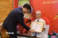 Đồng chí Nguyễn Duy Ngọc, Ủy viên Bộ Chính trị, Bí thư Trung ương Đảng, Trưởng ban Tổ chức Trung ương, trao tặng Huy hiệu 80 năm tuổi Đảng cho đồng chí Nguyễn Thanh Mậu. (Ảnh: Danh Lam/TTXVN)