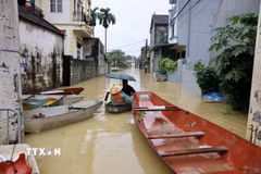 Khu dân cư ven sông Bùi ngập trong nước lũ, người dân phải dùng thuyền để di chuyển. (Ảnh: Nhật Anh/TTXVN)