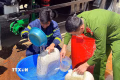 Các chiến sỹ Phòng cháy chữa cháy cùng Công an xã Pà Cò hỗ trợ phân phát nước cho người dân địa phương. (Ảnh: Thanh Hải/TTXVN)