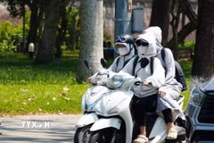 Người dân mặc đồ bảo hộ chống nắng khi di chuyển trên đường. (Ảnh: Nguyên Lý/TTXVN)