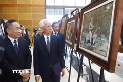 Đồng chí Khamphan Pheuiyavong, Ủy viên Bộ Chính trị, Trưởng ban Tuyên huấn Trung ương Lào và đại biểu tham quan triển lãm. (Ảnh: Xuân Tú/TTXVN)