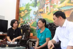Đại diện Lãnh đạo Mặt trận Tổ quốc Việt Nam thành phố Hà Nội và chính quyền địa phương thăm hỏi và hỗ trợ gia đình nạn nhân vụ cháy. (Ảnh: TTXVN phát)