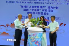 Đại biểu thực hiện hoạt động tưới nước cho cây càphê tại chương trình. (Ảnh: Công Luật/TTXVN)