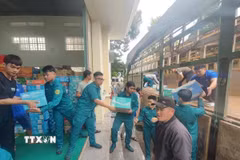 Lực lượng quân đội và nhân dân các xã phía Tây tỉnh Gia Lai sắp xếp hàng hóa gửi về cứu trợ đồng bào lũ lụt. (Ảnh: Hồng Điệp/TTXVN)