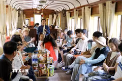 Biểu diễn âm nhạc phục vụ du khách trên chuyến tàu từ Ga Đà Lạt đến Ga Trại Mát (Lâm Đồng). (Ảnh: Nguyễn Huy Thành/TTXVN)