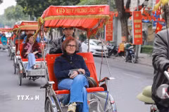 Du khách nước ngoài thích thú với khí hậu mát lạnh của Thủ đô Hà Nội. (Ảnh: Phan Phương/TTXVN)
